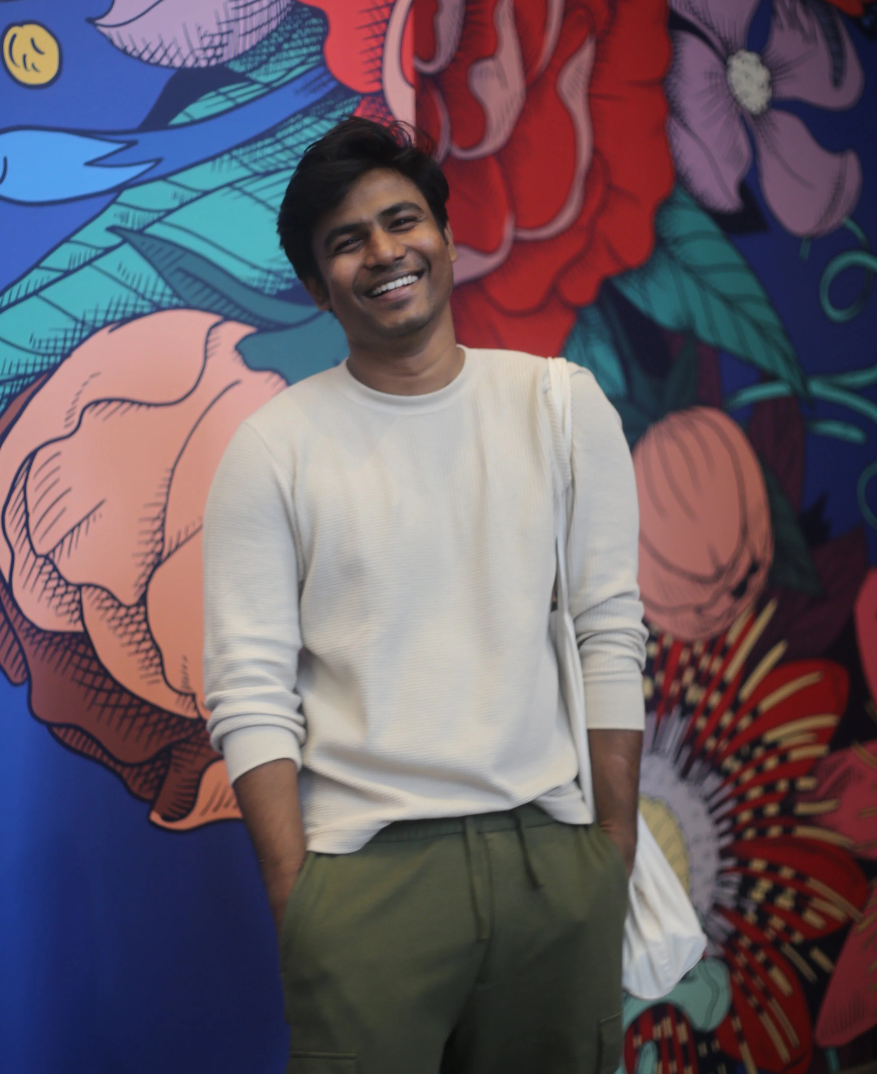 Linganesan smiling in a white t-shirt